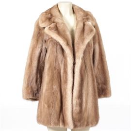 Vintage Fur Jacket: A vintage mink jacket. This autumn haze mink features a notched collar, vertical panel design and taupe silk lining with floral embellishment embroidered throughout. There is a tag to the interior which reads, “Designed for Betty” as well as a monogrammed BJD to the side. No maker’s tag is present.