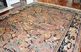 MJ Whittall Anglo-Persian "Bird of Paradise" Wool Area Rug: An Anglo-Persian Bird Of Paradise machine woven wool area rug by MJ Whittall. This fine machine woven wool rug features an all over Asian garden and bird scene with two small geometric borders and a wide floral border. The rug features tones of black, green, camel, and oatmeal, across a salmon field, and is finished with hand-knotted fringe. Rug coordinates with #17CIN294-292.