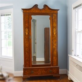 Antique Federal Style Wardrobe With Marquetry: An antique Federal style armoire. This burled walnut veneer and mahogany armoire features a broken scroll pediment with swag detailing and a burled walnut veneer panel. The cabinet is designed with a floral and vase marquetry detail, with burled walnut veneer panel, a center beveled mirror door, a lower drawer and ogee bracket foot. The lower drawer includes round loop pulls, a burled veneer drawer front, dovetail drawer construction. The door opens to three interior shelves.