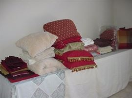 Lots of bed, table, and kitchen linens; pillows; napkins, sheets, blankets, throws, placemats