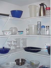Pantry full of bake ware, fridge storage pieces, glass mixing bowls, and other types of containers