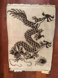 a chinese rug. small and hand woven dragon theme.