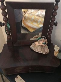 antique mahogany shaving mirror with antebellum doll. old thin hand done quilt in the mirror reflection.