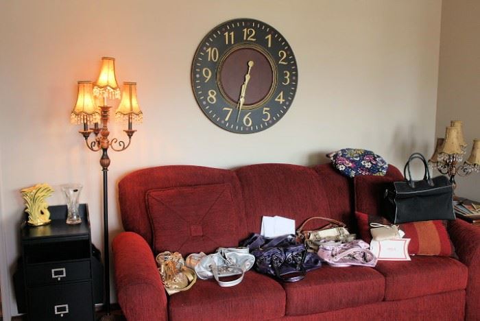 Couch filled with designer purses, HUGE working clock