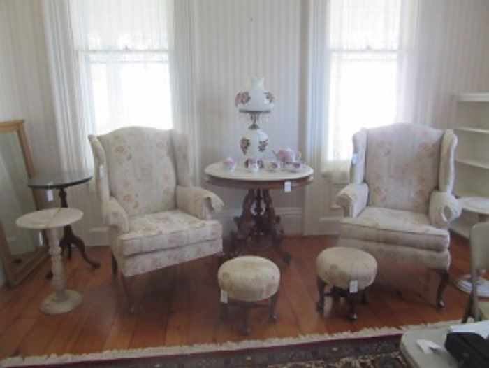 Harden upholstered chairs.  Round table beside on left and a marble stand. Central is a Marble top walnut table, with a Austrian tea set on top and a lamp.  In front of the chairs are two foot rest by Harden.