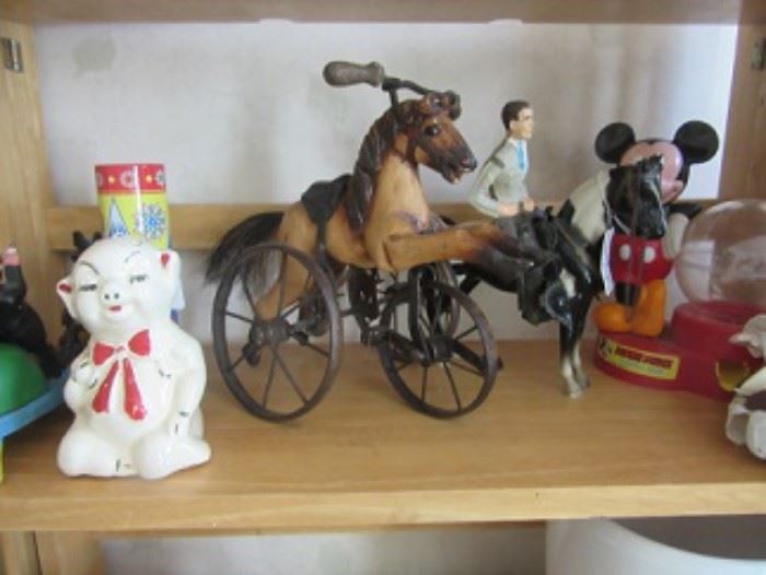 The piggy back on left is 1930-40's  The horse Tricycle is for a doll. The horse and rider next to it is plastic.  A Mickey Mouse gum ball machine is on the right. Kaleidoscope is behind piggy bank. 