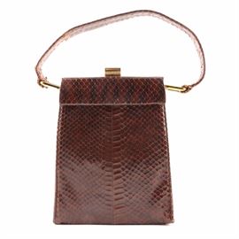 Vintage Brown Snakeskin Handbag By Susan: A vintage brown snakeskin handbag by Susan. This frame style bag features an elongated body with a single handle strap and gold tone clamp clasp. The interior is finished with green leather and retains a branded stamp that reads “Fashioned by Susan”.