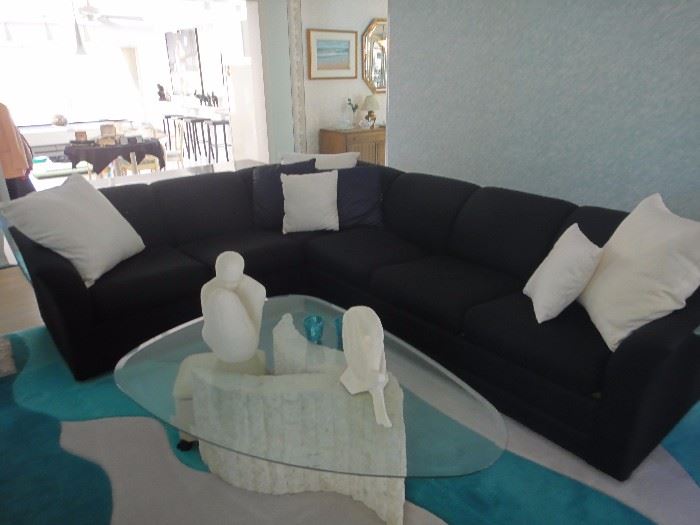 Black sectional sofa, Excellent condition. Sleeper sofa also. Glass top sculpted coffee table . Ceramic figurines and sculptures. 