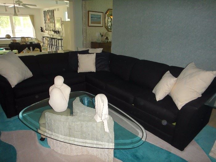 Black sectional sofa, Excellent condition. Sleeper sofa also. Glass top sculpted coffee table . Ceramic figurines and sculptures. 