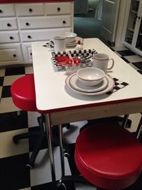 Colorful table with rolling red stools