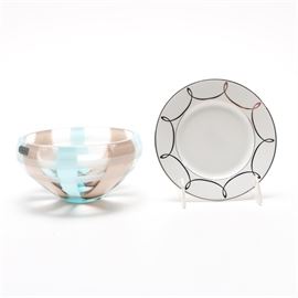 Waterford Tableware: A pair of Waterford tableware pieces. This pair of Waterford tableware items features a bone china bread and butter plate decorated in the Lismore Essence pattern marked “Waterford” to the underside. Also included is a blue, brown and clear glass bowl etched “Evolution by Waterford” and labeled “espresso swirl” to the underside.