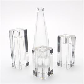 Kosta Candle Holders and Vase: A collection of glass and crystal décor by Kosta. This collection includes a tall, teardrop-shaped glass vase with a foliate design and three square lead crystal candle holders of different heights. The vase is marked “Kosta A 3054” and the candle holders are labeled “Handmade Kosta Crystal Collection Full Lead Crystal” and marked “Kosta 68307 Ehrner”.