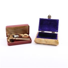 Set of Decor and Vanity Boxes: A set of decor and vanity boxes. This set includes a box constructed of bone with brass detail and red and green pieces to the top. The interior of the box is lined with purple velvet. The vanity box is marked “Improved Ever-Ready Safety Razor” and contains a razor, lock and thimble. The box is red on both the interior and exterior.
