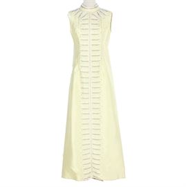 Vintage Yellow Beaded Dress: A vintage yellow beaded dress. This sleeveless dress features a high collared neckline and a pleated back split. The front of the dress and around the neckline features a gray and white beaded line design.
