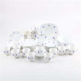 Large Set of White and Blue Porcelain Tea Service Pieces: A large set of blue and white porcelain tea service pieces. This forty-three piece set includes two large plates, nine bread and butter plates, nine saucers, two deep saucers, six saucers, ten tea cups, a creamer, a sugar bowl, a bowl and two pitchers. The pieces have blue foliate designs in low relief around the rims, with subtle vine designs just inside the edges. They have no identifying markings.