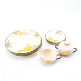 Assorted Franciscan Dishware: An assortment of Franciscan ceramic dishware. The tableware has hand-painted floral accents in yellow, green, and purple. Included are four dinner plates, three dessert plates, one sugar, and one creamer. The pieces are marked to the underside “Franciscan Made in California”.