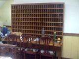 Antique Postal Letter Case from the post office in Hawkinsville, GA. Bought from the post office when they renovated for metal boxes. Tag on bottom states originally made for the postmaster in Iva, South Carolina. Piece was made in Michigan with original tag attached underneath; Mahogany Chairs;