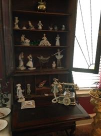 Antique secretary with various figurines; vingtage looking telephone