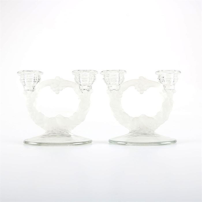 Glass Candelabra Pair with Bowl: A pair of glass candelabras with a matching bowl. These pieces feature circular columns made of frosted glass in the form of grape vines and are each adorned with a pair of hive shape candle holders. The matching bowl features scalloped edges with a frosted fruit motif along the base. There are no maker’s marks present.