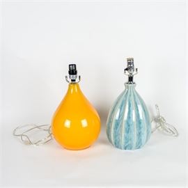 Pair of Table Lamps: A pair of table lamps. The orange one is glass and the blue one is ceramic. They both have similar shapes. The blue one is vertically ribbed.