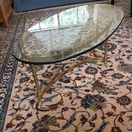 
This is mid-century brass and glass oval cocktail table and very Hollywood Regency.  The maker is Labarge Italy. 
