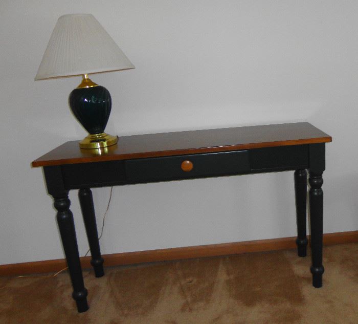 Small sofa table painted dark green, plain dark wood top and middle drawer