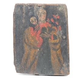 Antique Retablo Nuestra Señora del Refugio de los Pecadores: A sweet, naif, early 19th century Spanish Colonial Retablo image on pine board of Mary holding the infant Jesus, the Nuestra Señora del Refugio de Pecadores (Our Lady, Refuge of Sinners). The image shows Mary a red dress and light robe holding the infant in her left arm and a bouquet of red flowers in her right. The rustic painting is executed in black, red blue and yellow on a rough hewn board. There are remnants of a brand from mounting. 1938.0551