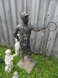 antique lawn jockey along with smaller concrete statues
