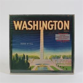 Framed Washington Brand Exeter Orange Growers Association Crate Label: A framed Washington Brand Exeter Orange Growers Association crate label. This offset lithograph depicts the Washington Monument from across the reflecting pool. The capital is also visible in the distance. Across the top of the label “Washington” is printed in capital letters with the word “Brand” printed in smaller text below it. In the same area, “Grown & Packed by Exeter Orange Growers Association Exeter- California U.S.A.” is printed in red letters. This label is presented in a silver tone metal frame, under glass.