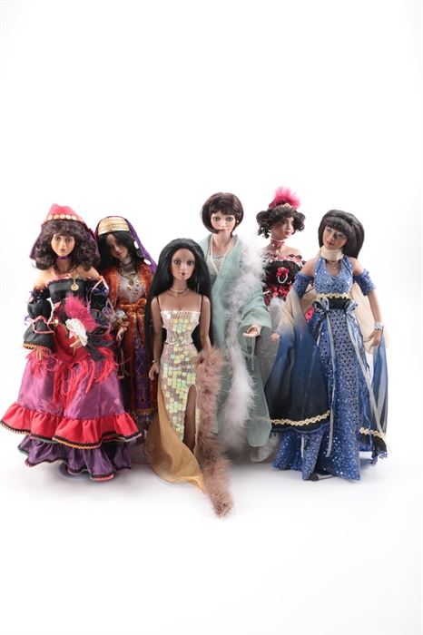 Collectible Dolls: A collection of six dolls. This group includes dolls that represent adult females in various outfits including evening gowns, a 1920s flapper style, a flamenco dancer and more. The doll in the black red and white off the shoulder gown is marked to the neck “AEL A474”.