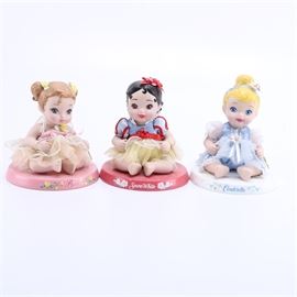Disney Princess Baby Dolls: A selection of three Disney Princess Baby dolls. Included are baby dolls of three Disney Princesses Belle, Snow White, and Cinderella in chiffon and lace outfits with small hair decorations on decorated bases.