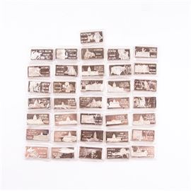 Large Grouping of Hamilton Mint State Themed One Troy Ounce .999 Silver Ingots: A large grouping of approximately 36 Hamilton Mint state themed one troy ounce .999 silver ingots. States range from Alaska to Wyoming, including two Delaware ingots. See pictures for exact states. The obverse of each rectangular bar features a relief image of a given state, the name, its number out of 50, and the date it became officially recognized. The reverse features a relief of the capital building, similar information, and “one troy oz. .999 F.S. HM75P”. Each comes in a protective plastic sleeve. See also 17CIN316-066.