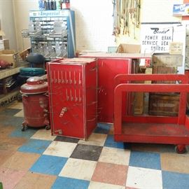 Far left, one of several multi-bin storage units. Red 1940's stock cart. Vintage advertising.