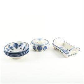 Louisville Stoneware "Bachelor Button" Tableware: A group of Louisville Stoneware Bachelor’s Button tableware items. This group includes a lidded bowl, a bread tray with cut-out handles, and four bowls. All feature hand-painted blue flowers and blue trim over a glossy bisque background. They are marked on the underside.
