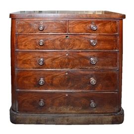 Vintage Flame Mahogany Chest of Drawers: A vintage flame mahogany chest of drawers. This chest of drawers features a rectangular top above a set of two side by side drawers and four full width drawers. Each drawer has two wooden knobs to the front. The piece rests on a platform base with curved sides.