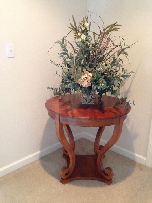 Round wooden table with striking flower arrangement