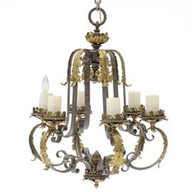 Wrought and Cast Iron Six-Light Chandelier: A heavy wrought and cast iron chandelier with brass-tone highlights and foliate detail, having an ornate ceiling canopy and six arms with electric sockets. Circa 1920-30s. Direct wired, untested.