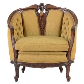 Swan Carved Bergeré Chair: A finely carved, French style bergeré / arm chair, having a rounded form with swan carved back and cabriole legs, upholstered in the original fabric, circa 1930.