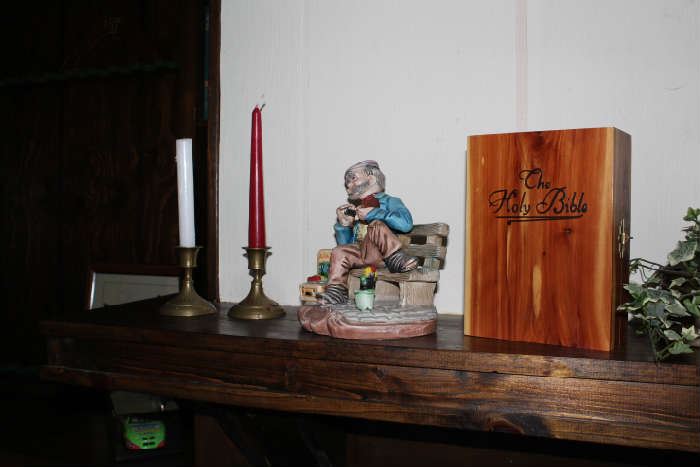 Holy Bible in a wood box, brass candlesticks, Man on bench table decor
