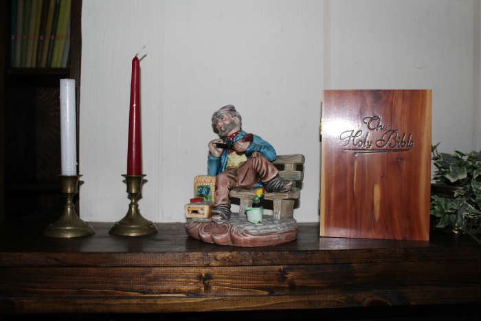Holy Bible in a wood box, brass candlesticks, Man on bench table decor