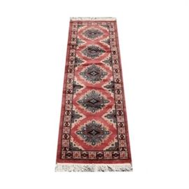 Handwoven Bokhara Rug Runner: A handwoven Bokhara rug runner. This rug runner has a central medallion repeating pattern featuring bright rose, ivory, silver, and light blue tones. It has a single border in matching tones featuring a repeating floral and geometric pattern. The rug has fringe to either end and is unmarked.
