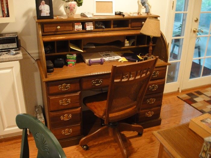 Solid wood rolltop desk with vintage rolling desk chair.