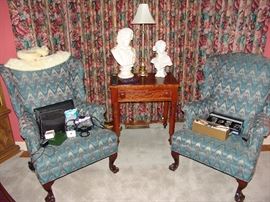 Pair of antique ball and claw wing chairs upholstered in  blue fabric and primitive cherry lamp or candlestick table with original pulls on drawer and turned legs