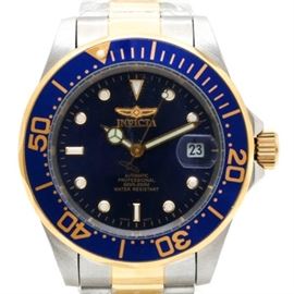 Invicta Stainless Steel Automatic Wristwatch: An Invicta automatic wristwatch with a two-tone stainless steel link bracelet leading up to a blue bezel with gold tone, scalloped trimming, minute indicators, and a screw crown. The bezel houses a blue dial with white hour indicators and hands in gold tone trimming. A magnified date subdial appears at the 3 o’clock position. Included with this wristwatch is a yellow Invicta storage box and instruction manual.