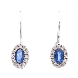 14K White Gold Sapphire and Diamond Earrings: A pair of 14K white gold sapphire and diamond earrings. Each earring features a central blue sapphire surrounded by a diamond halo.