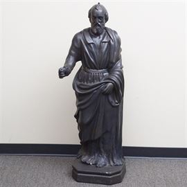 Plaster Religious Statue: A religious statue made of plaster. This piece depicts a man in a robe and sash, one arm holding his sash and the other partially outstretched.