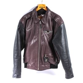 Harley-Davidson 95th Anniversary Leather Bomber Jacket: A Harley-Davidson 95th anniversary leather bomber jacket. Featured her is a leather coat with black long sleeves and a maroon body. The front of the jacket and side pockets zip closed and there are multiple insignias on the zippers and jacket. There is a snap closed internal pocket and the jacket is marked size medium. The back fo the jacket has a large “Harley-Davidson, 95 Years” design.