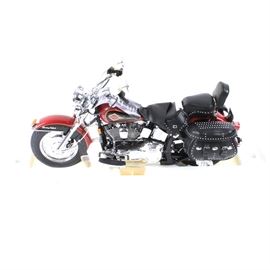 Franklin Mint 1:50-Scale Harley-Davidson "Heritage Softail Classic" Replica Model: A Franklin Mint 1:50-scale Harley-Davidson “Heritage Softail Classic” replica model motorcycle. The highly detailed model motorcycle is made of die-cast metal, with leather and other materials. The body is red and black, and the motorcycle model has black seats and saddle bags, with chrome colored trim. The model motorcycle comes in the original box with paperwork.