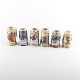 Decorated Ceramic Beer Steins: A collection of six decorated ceramic beer steins. Includes one Budweiser stein, two Anheuser Busch steins, two Ducks Unlimited steins, and one Stroh’s stein. The steins are marked to their undersides.