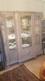 Fabulous Intricately carved cabinet with lights above, glass shelves, north wind faces on top corners and center panel below, great claw feet